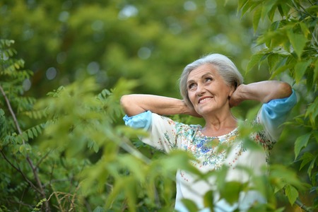 Portrait of a beautiful senior woman in green parkの写真素材