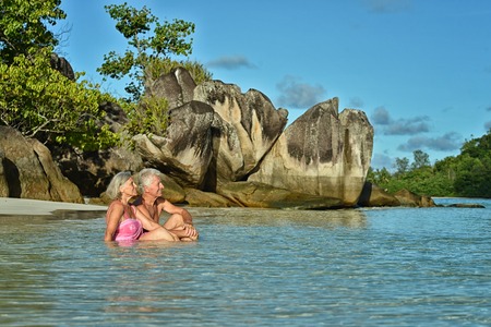 Happy elderly couple rest at tropical beach