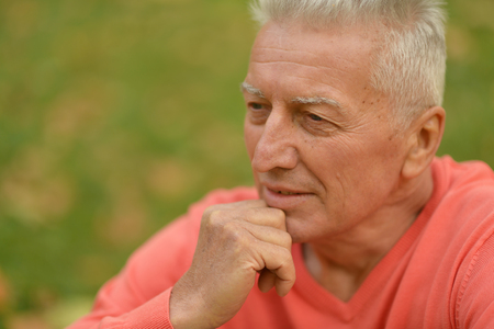 Happy elderly man enjoying in autumn parkの写真素材