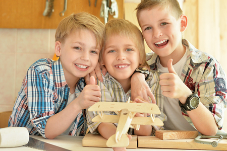 cute little boys  working with wood in  workshopの写真素材
