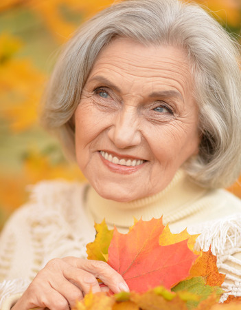Portrait of a beautiful middle-aged woman in autumn park