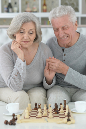 happy Senior couple resting at home and playing chessの写真素材