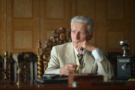 Mature male mafia boss on the table with gunの写真素材