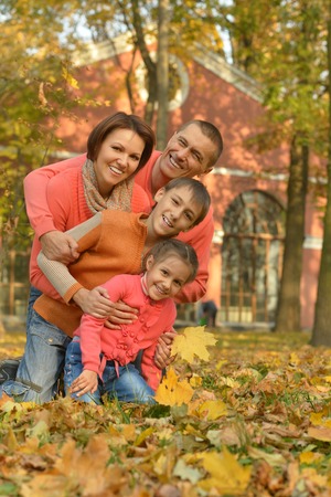 Happy smiling family relaxing in autumn parkの写真素材