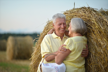 Beautiful happy senior couple in summer fieldの写真素材