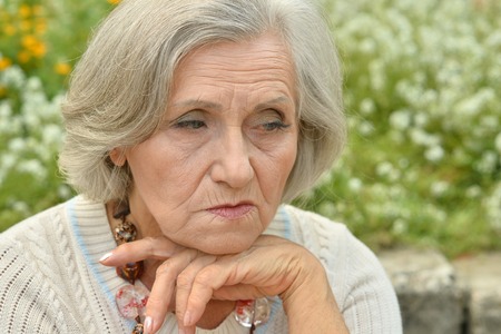 Nice sad old woman on the spring backgroundの写真素材