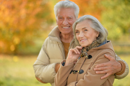 Portrait of a beautiful happy middle-aged couple in the autumn parkの写真素材
