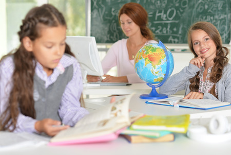Portrait of teacher with two girls at lessonの写真素材