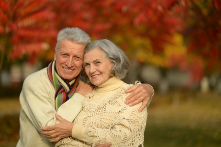 Portrait of a happy senior couple in autumn parkの写真素材