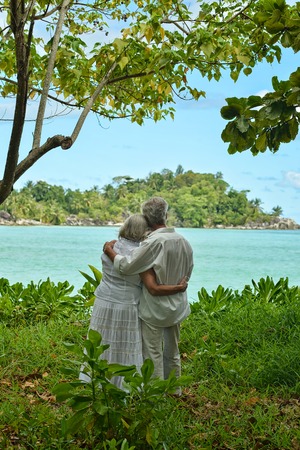 Happy elderly couple rest at tropical beacの写真素材