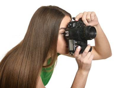Young beautiful caucasian woman with camera over white background