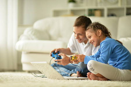 Portrait of a happy children with laptop at home