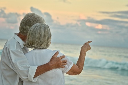 Happy elderly couple rest at tropical beachの写真素材
