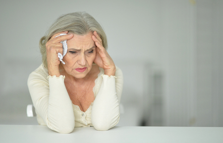 Portrait of sad senior woman with headacheの写真素材