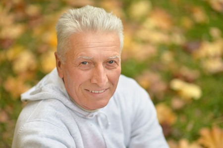 Happy elderly man enjoying in autumn parkの写真素材