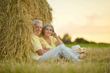 Beautiful happy senior couple in summer fieldの写真素材