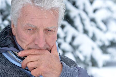 mature man thinking about something, fir trees on background