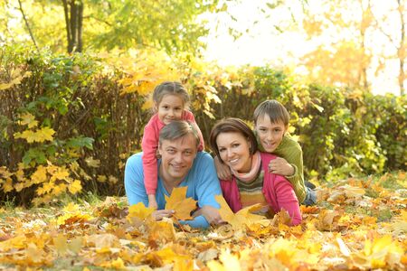 Happy family in autumn parkの写真素材