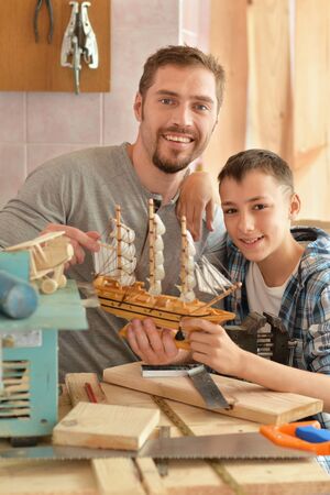 father and son with wooden shipの写真素材