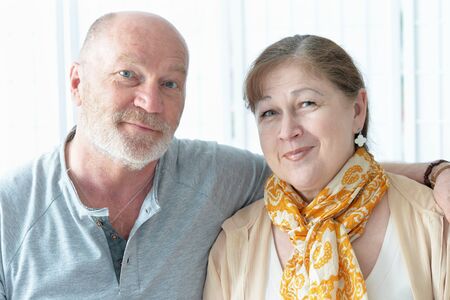 Happy elderly couple standing embracing