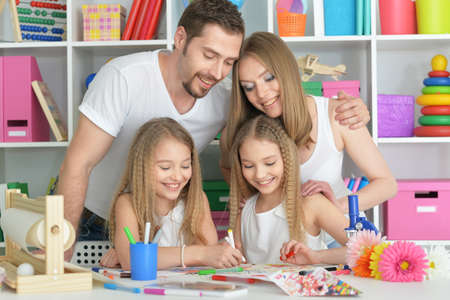 Happy parents with children  at homeの写真素材