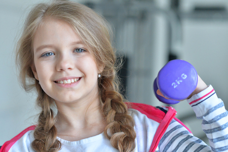 Teenage girl in the gym with dumbbellsの写真素材