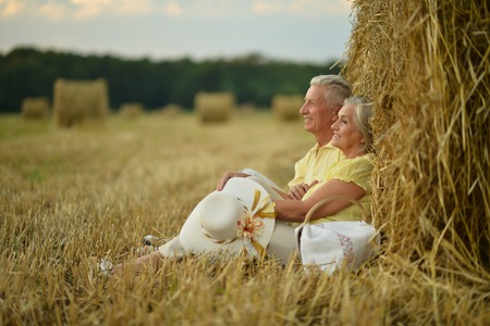 Senior couple on mowed field of wheatの写真素材