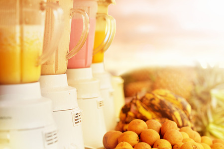 Row of blenders with fresh smoothies and fruits nearbyの写真素材
