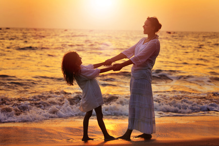Mother and daughter on sandy beachの写真素材