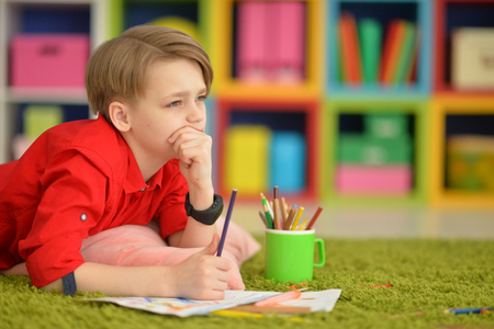 Cute boy drawing with pencilsの写真素材