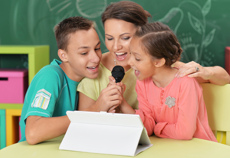 Mother and children singing karaokeの写真素材