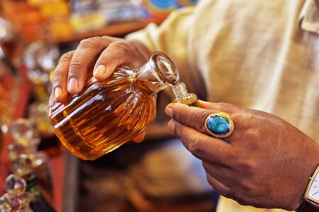 Man pouring essential oil from glass bottleの写真素材