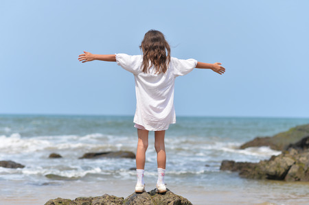Little girl standing on rockの写真素材