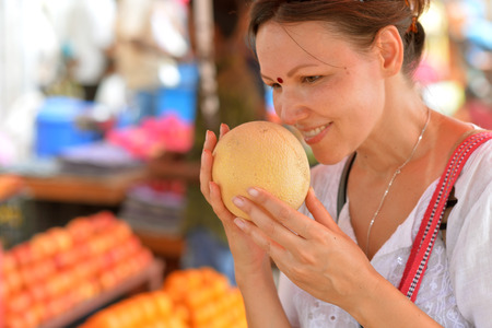 Young woman sniffing fruitの写真素材