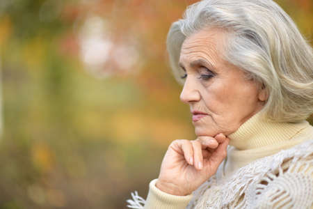 Senior beautiful  sad woman posing outdoorsの写真素材