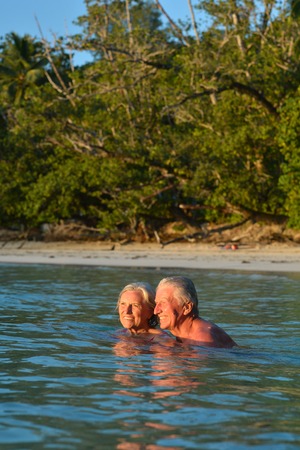elderly couple in sea waterの写真素材