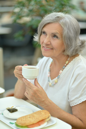 elderly woman in cafeの写真素材