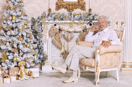 Senior man near Christmas treeの写真素材