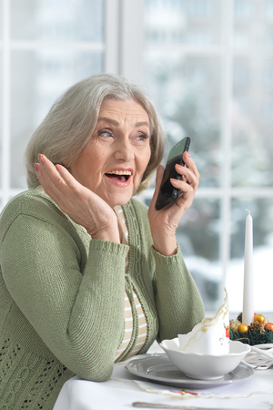 woman sitting at table  with phoneの写真素材