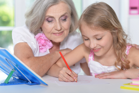 grandmother and granddaughter doing homeworkの写真素材