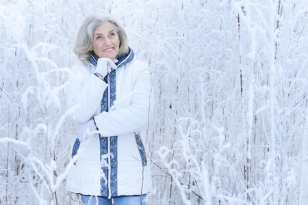 mature woman in winter posing outdoorsの写真素材