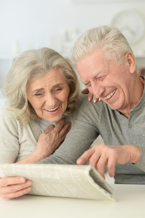 senior couple with newspaper  at homeの写真素材