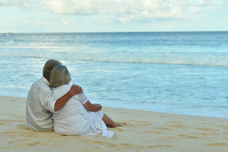 elderly couple running  on beachの写真素材