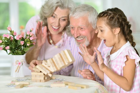 grandparents and granddaughter playing with wooden blocksの写真素材