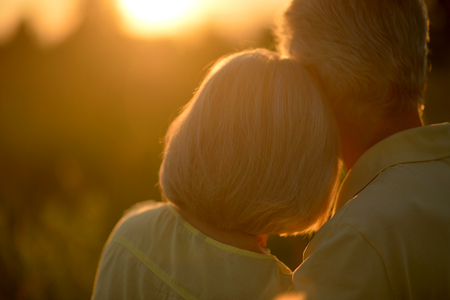 Rear view of senior couple hugging in parkの写真素材