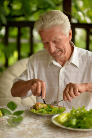 Portrait of handsome senior man eating breakfastの写真素材