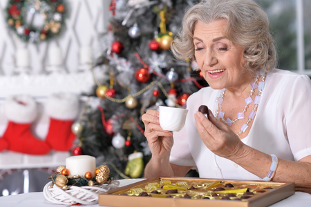 woman with  chocolates and  cup of teaの写真素材