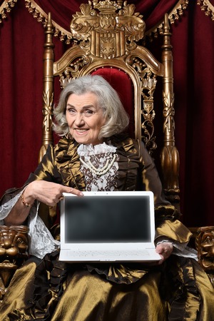 Portrait of senior woman sitting in vintage chair