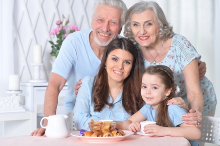 Portrait of happy family posing near table