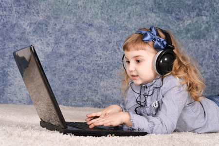 Portrait of a beautiful cute girl using laptopの写真素材
